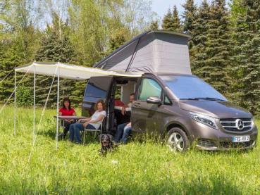 Brandrup TOP-SAIL Sonnensegel in der Farbe 'Reflexsilber/Red Gold' neben einem Mercedes-Benz Marco Polo Reisemobil, aufgestellt auf einem sonnigen Campingplatz, bietet Schatten und Schutz vor Sonneneinstrahlung.